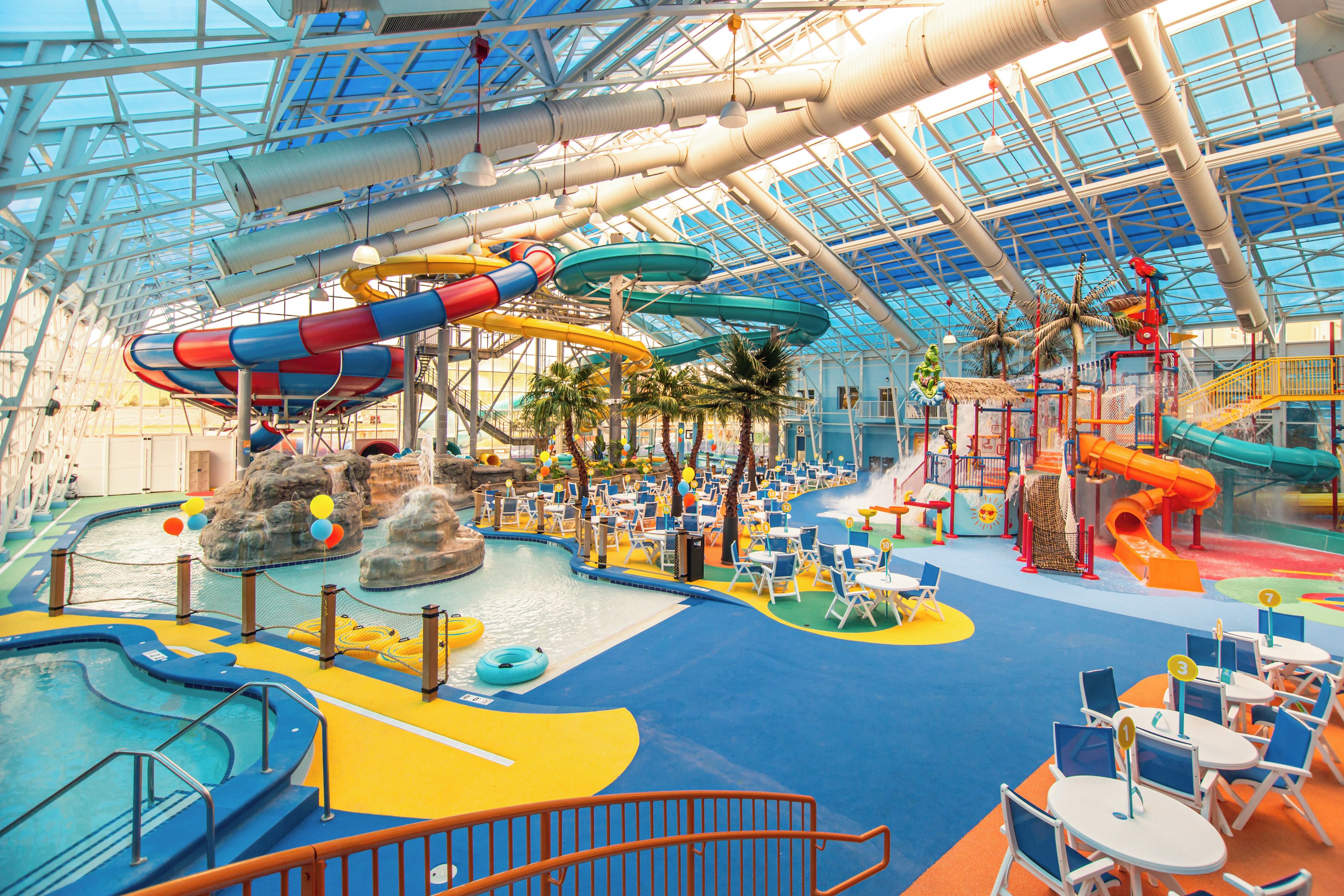 An indoor water park with slides, pools, and play areas.