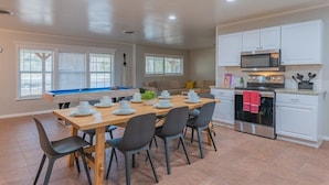 A modern kitchen with white cabinets, a stainless steel oven, and a microwave. - Private Pool, Game Room, Fire Pit & Huge Backyard near Six Flags (San Antonio)