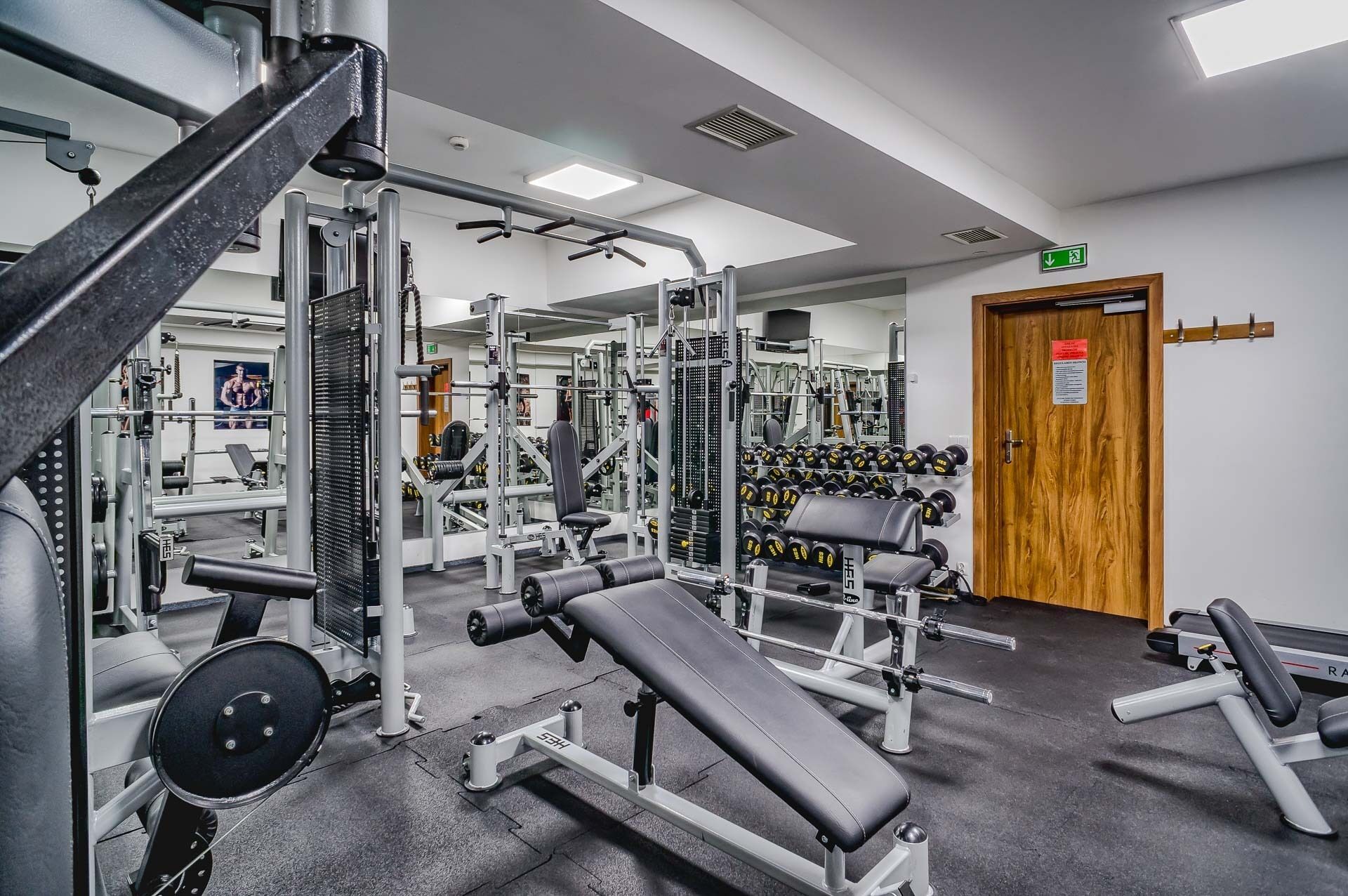 A gym with various exercise equipment, including weight machines and dumbbells.
