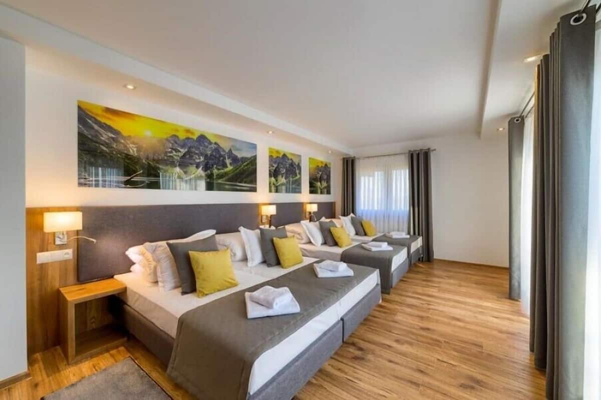 Ein Hotelzimmer mit einem großen Bett, einem Nachttisch und einem am Wand montierten Fernseher.
