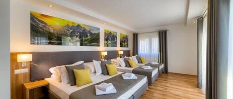Una habitación de hotel con una cama grande, una mesita de noche y un televisor montado en la pared.