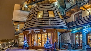 Un hôtel doté d’une façade traditionnelle en bois, d’un espace de réception et de places assises en plein air.