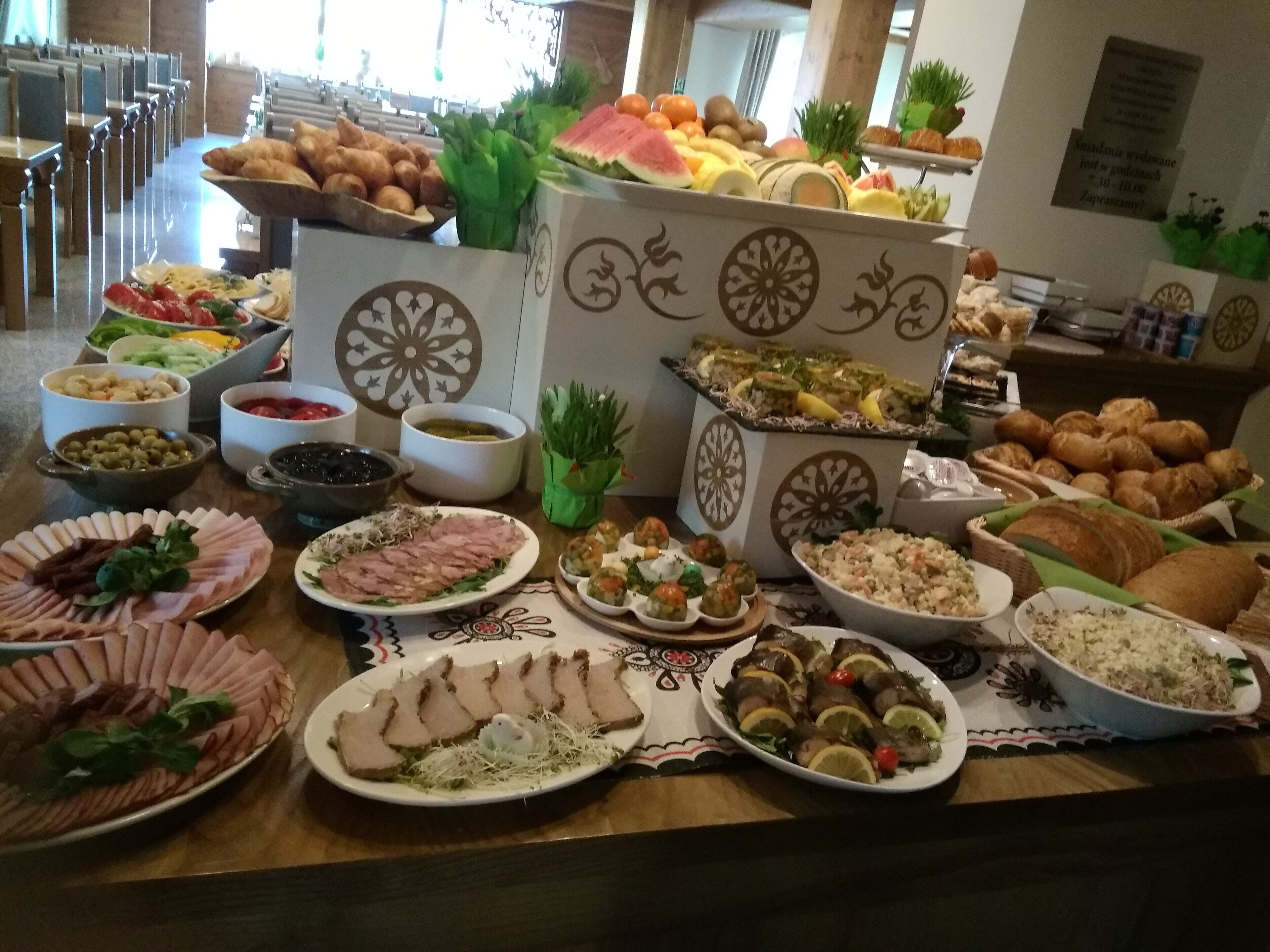A buffet table with various food items including meats, cheeses, and pastries.