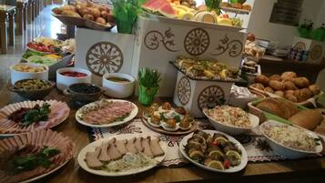 A buffet table with various food items including meats, cheeses, and pastries.
