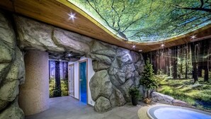 Un espace spa agrémenté d’un mur en pierre, d’une porte bleue et d’une grande piscine intérieure.