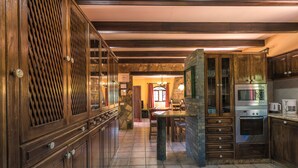 Una cocina con armarios de madera, una pared de piedra y un horno empotrado.