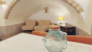 A cozy room with a white table, two beige armchairs, a lamp, and a decorative glass vase. - Tourist Location Joy's Home (Bari)