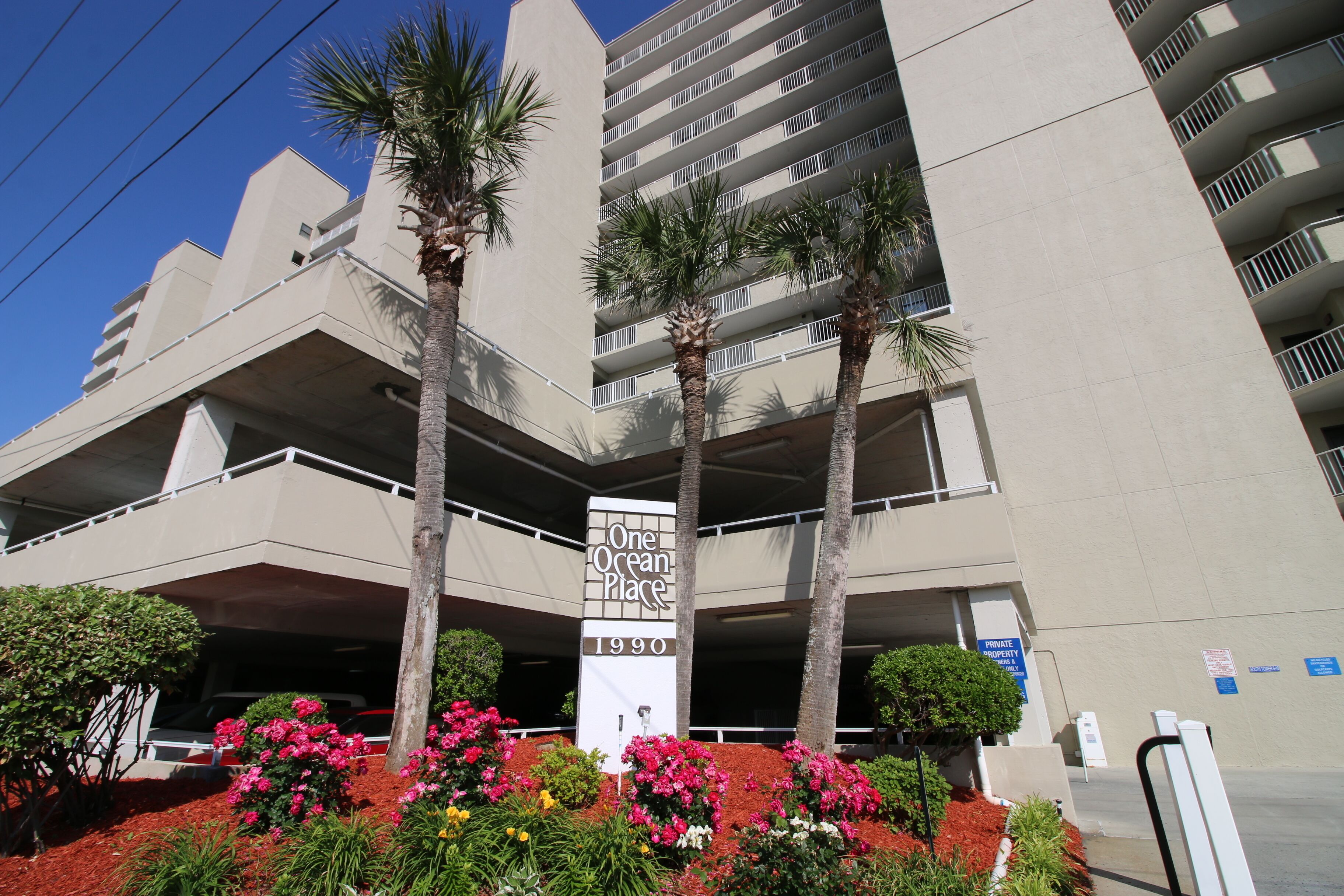 A multi-story parking garage with a sign reading "One Ocean Place 1990".