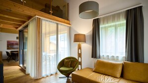 A modern living room with a sofa, a chair, a lamp, and a view of the outdoors. - 46282 Montan 28 OG (St. Gallenkirch)
