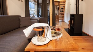 A cozy living room with a wooden table, a glass decanter, and a wine glass.