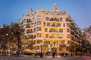 Un edificio de varios pisos con un estilo arquitectónico único, que presenta balcones y una fachada distintiva.
