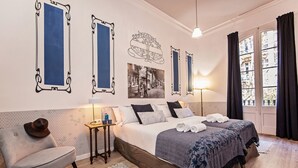 Une chambre d’hôtel avec un lit, une chaise, une table et une fenêtre.