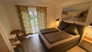 A bedroom with a bed, a desk, and a chair.