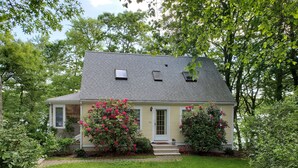 A single-story house with a grey roof, yellow siding, and a front porch.
