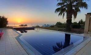 Alberca al aire libre y camastros 