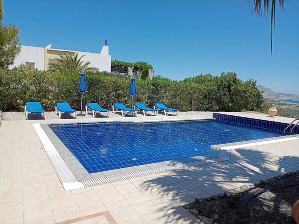 Alberca al aire libre y camastros 