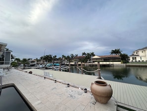 A marina with docked boats, a large ceramic pot, and residential buildings in the background.