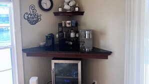Eine Küche mit einem eingebauten Kühlschrank, einer Kaffeemaschine und einer Uhr an der Wand.