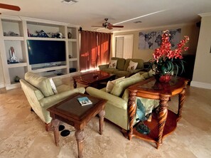 A living room with a sofa, coffee table, and a decorative table with a plant.