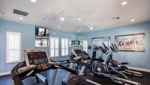 Ein Fitnessstudio mit Laufbändern, Crosstrainern und einem Ergometer.