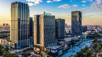 Un hotel de gran altura con un letrero de Holiday Inn Express, rodeado de otros edificios altos y un paisaje urbano.