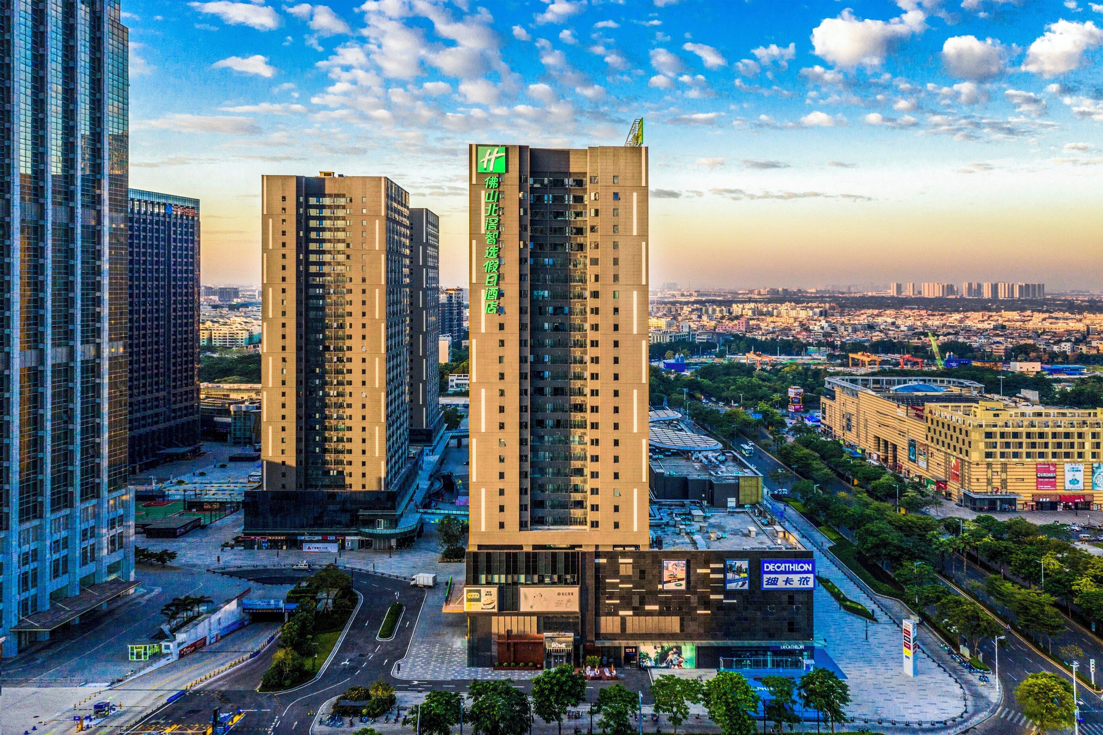 A high-rise building with multiple floors, surrounded by other tall buildings, and a view of a cityscape in the background.