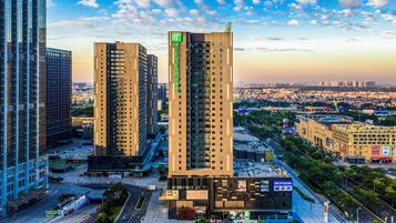 A high-rise building with multiple floors, surrounded by other tall buildings, and a view of a cityscape in the background.