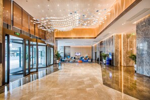 A modern lobby with a marble floor, seating area, and a glass entrance. - Holiday Inn Express Foshan Beijiao by IHG (Foshan)