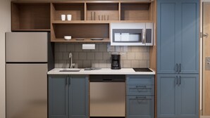 A modern kitchen with a built-in microwave, a coffee maker, and a dishwasher. - Candlewood Suites Midland South I 20 by IHG (Midland)