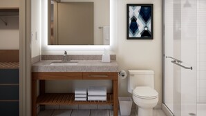 A modern bathroom with a large mirror, a sink, a toilet, and a shower. - Candlewood Suites Midland South I 20 by IHG (Midland)