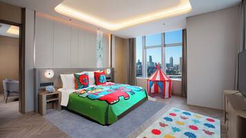 Habitación de hotel moderna con una cama grande, vistas a la ciudad, un escritorio y un televisor.