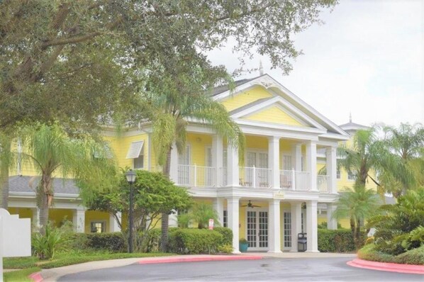 A yellow building with a balcony and white columns, surrounded by greenery. - Great Location - Close to Disney (Davenport)