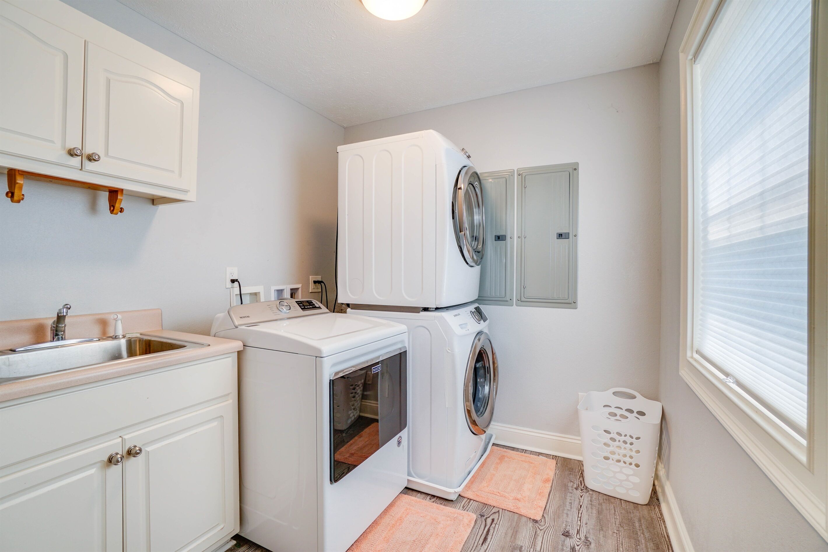 Un cuarto de lavandería con lavadora, secadora y lavabo.