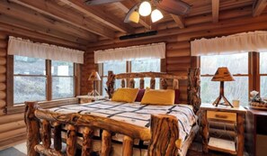 Cozy bedroom with a large bed, wooden headboard, and two bedside tables with lamps.