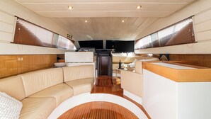 A boat interior with a curved wooden deck, a sofa, and a small table. - Gi&Gi ULTIMA......... a boat for dreaming (Bari)