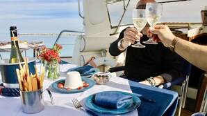 A table set for two with a bottle of champagne, a vase of flowers, and a plate of food. - Gi&Gi ULTIMA......... a boat for dreaming (Bari)
