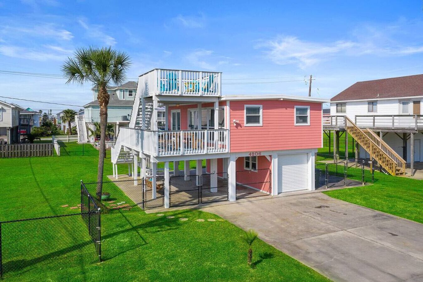 A two-story house with a balcony, a garage, and a fenced yard.