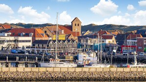 Un port avec des bateaux, une église et des bâtiments aux couleurs vives.