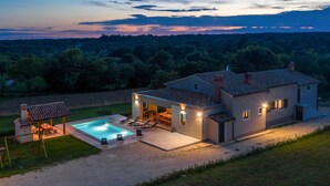 A modern house with a swimming pool, outdoor seating, and a view of the surrounding forest. - Beautiful home in Orihi (Orihi)
