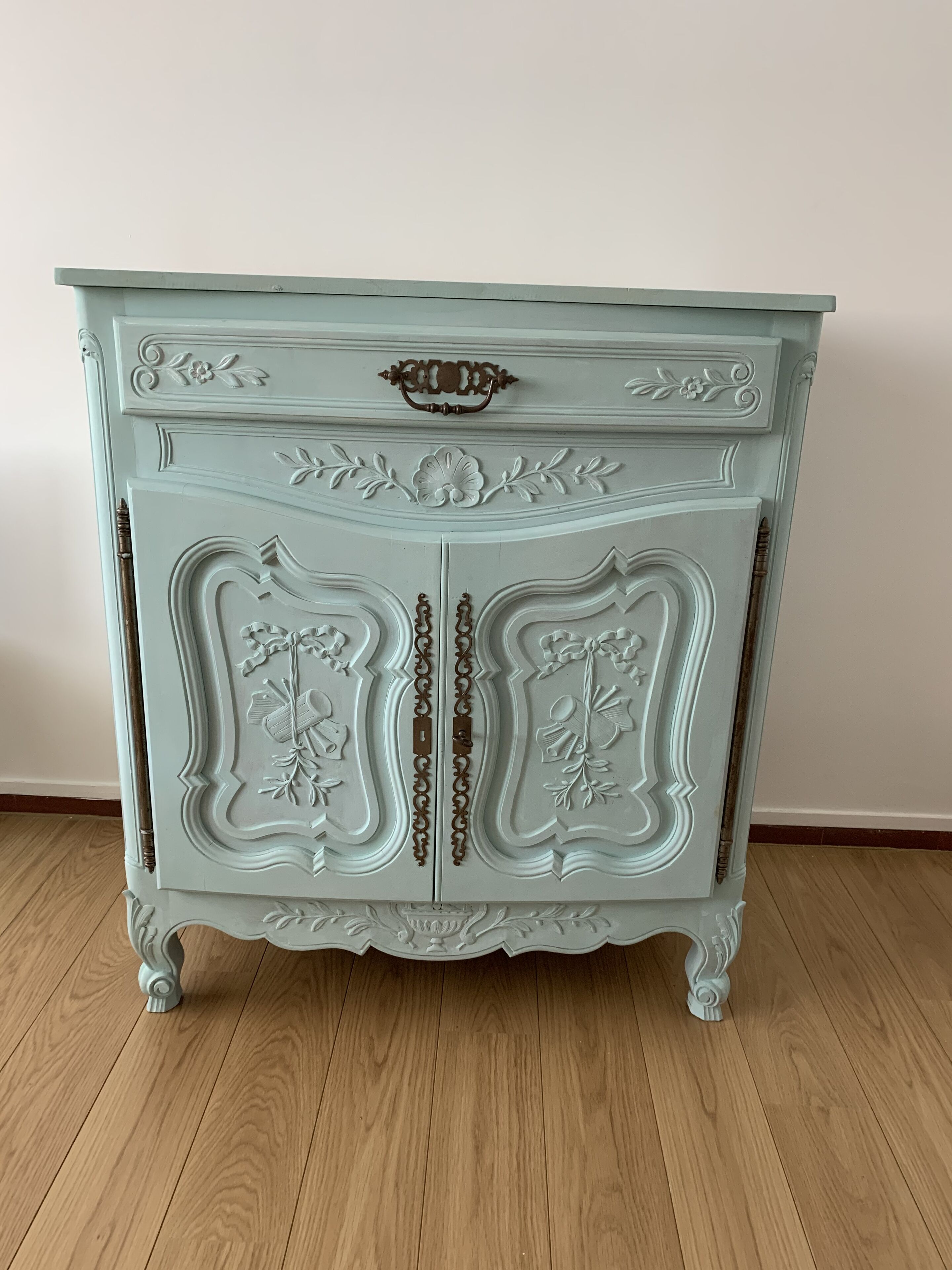 A light blue antique-style dresser with ornate carvings and a single drawer.