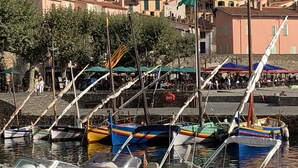 A marina with boats docked, a stone staircase leading to a town, and buildings in the background. - Appartement 4 personnes vue mer (Collioure)