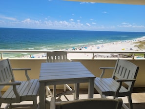 A balcony with a view of a beach and ocean.
