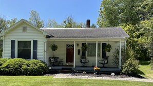 A single-story house with a porch, a front door, and a chimney. - CHARMING HOME CLOSE TO WATKINS GLEN & INTERNATIONAL RACETRACK (Montour Falls)