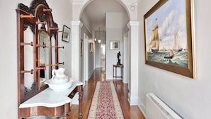 A hallway with a wooden bench, a mirror, and a painting of a sailing ship. - Hampden Manor A Refined Battery Point Period Home (Battery Point)