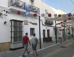 Un hotel llamado 'La Espanola' con fachada blanca, balcones y mesas al aire libre.