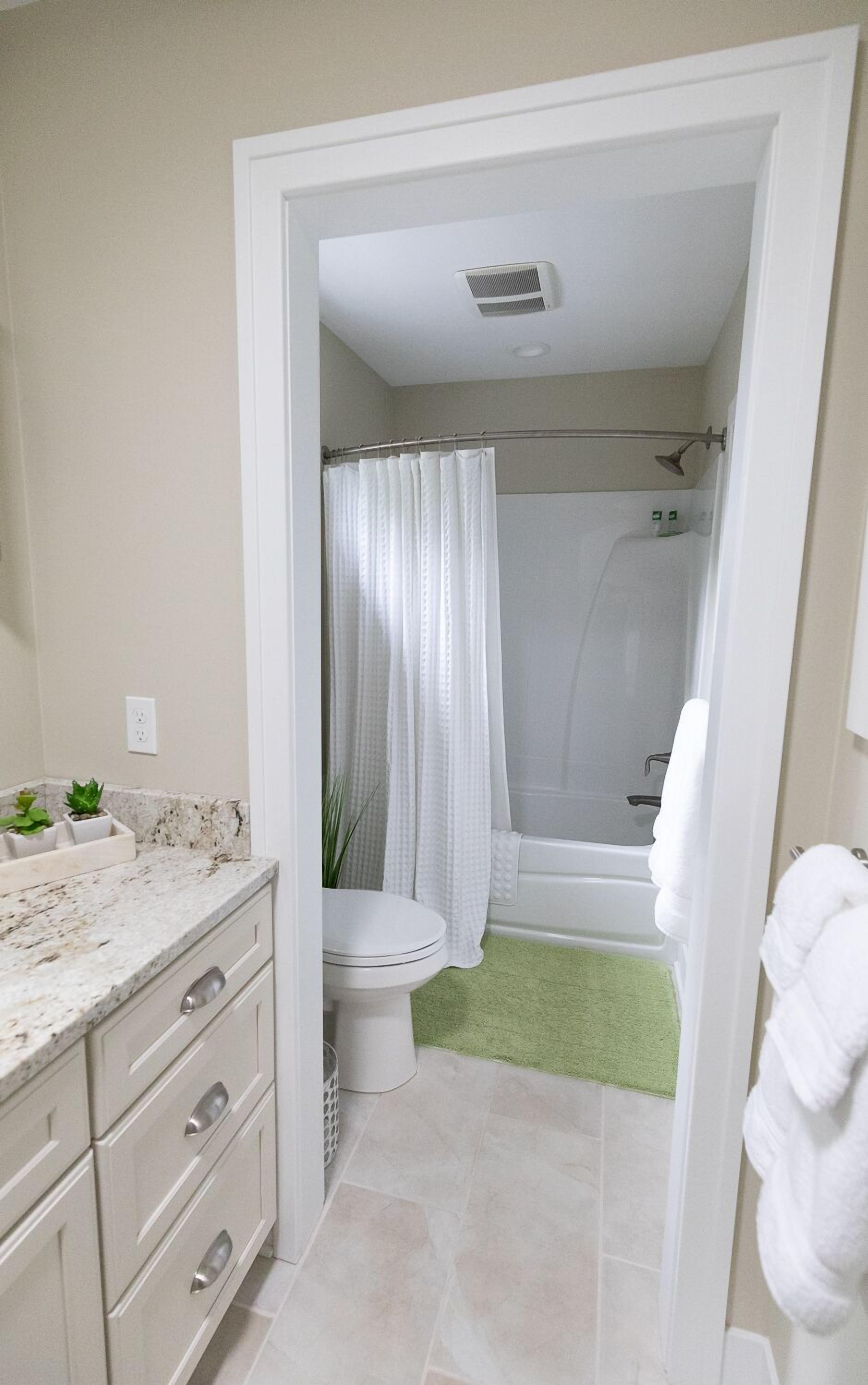 A bathroom with a toilet, shower, and bathtub.
