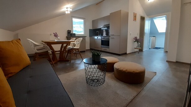 Un appartement moderne de style « loft » comprenant un coin repas, une cuisine et un espace de vie.