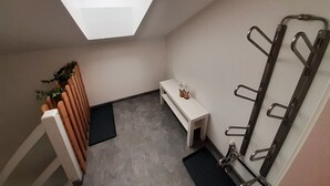 Une petite salle de bain moderne avec un puits de lumière, un banc et un porte-serviettes.