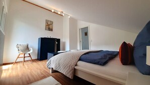 Une chambre à coucher moderne avec un lit, un bureau et une chaise.