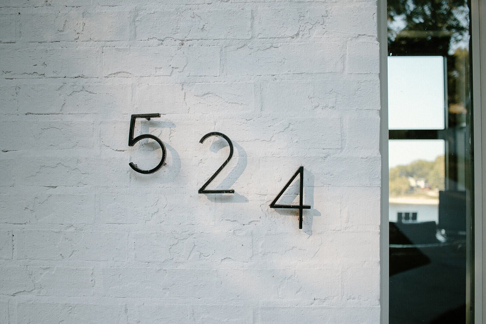 A white brick wall with the numbers "524" mounted on it.